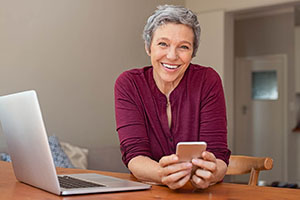 Smiling Woman with phone and computer